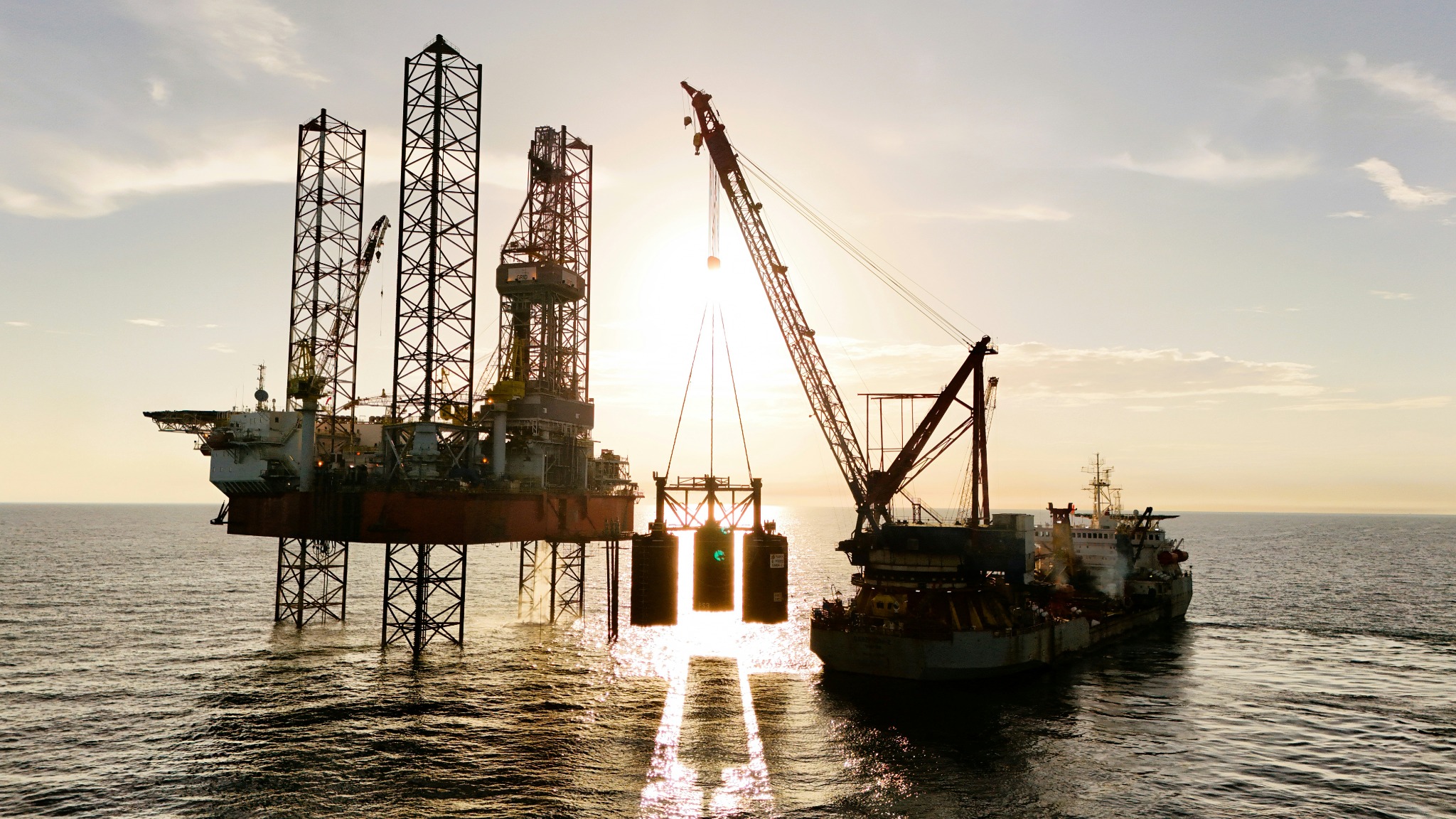 Offshore energy infrastructure at sea during golden-hour operations